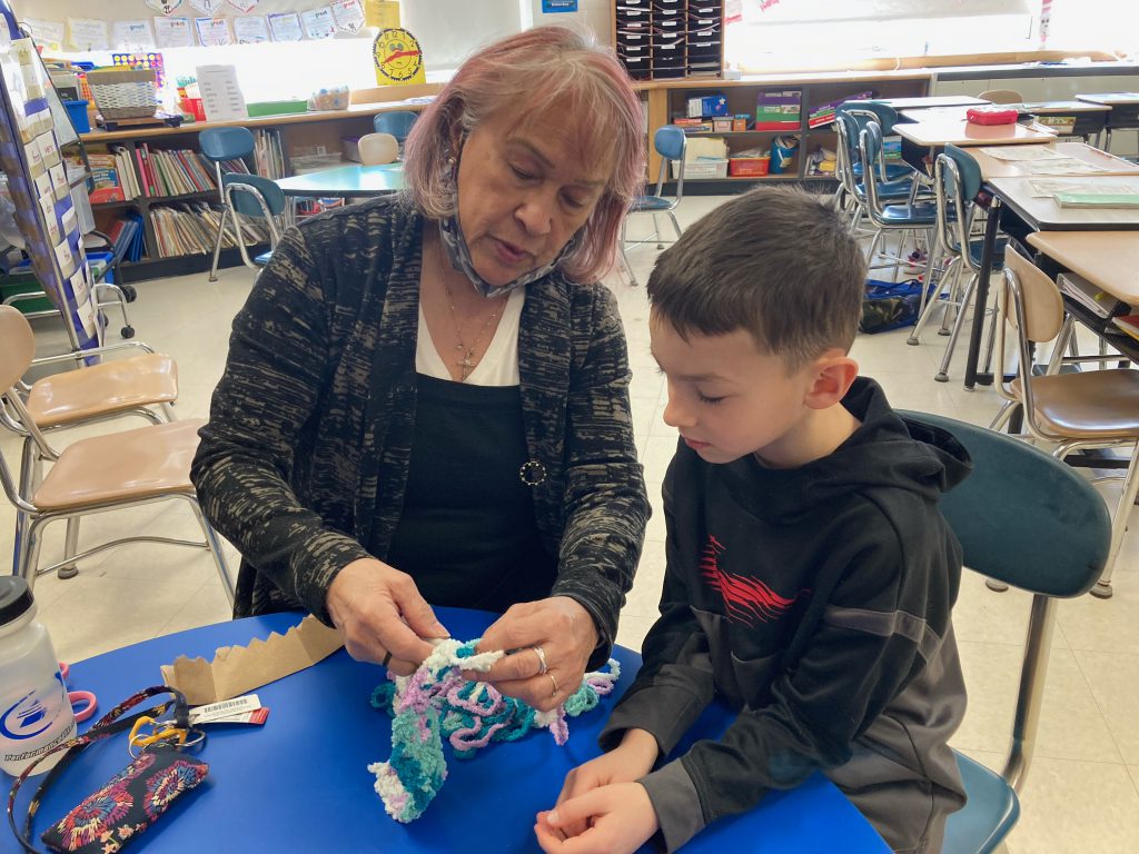 Judy teaching a student how to knit.