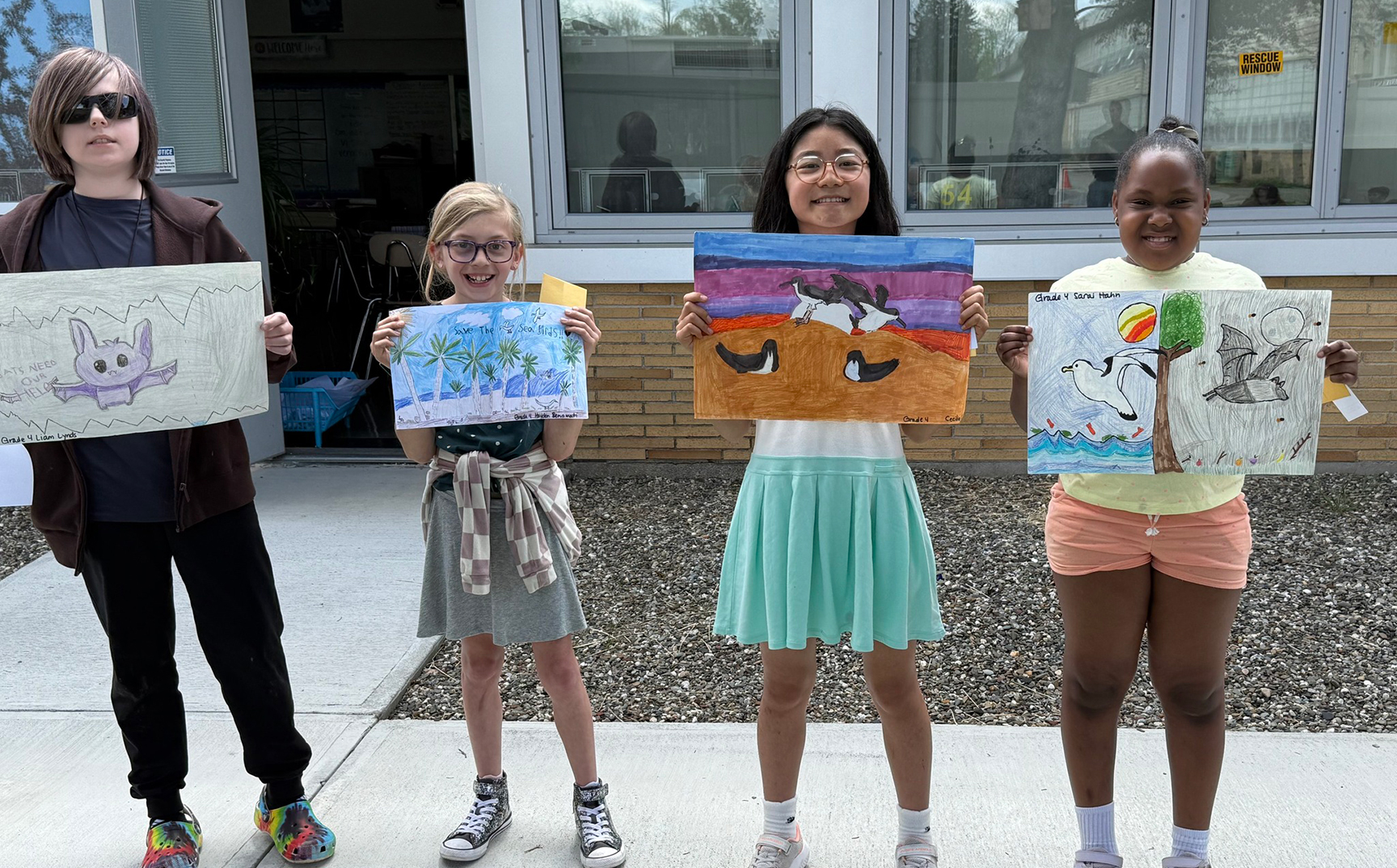 Elementary students posing with their posters