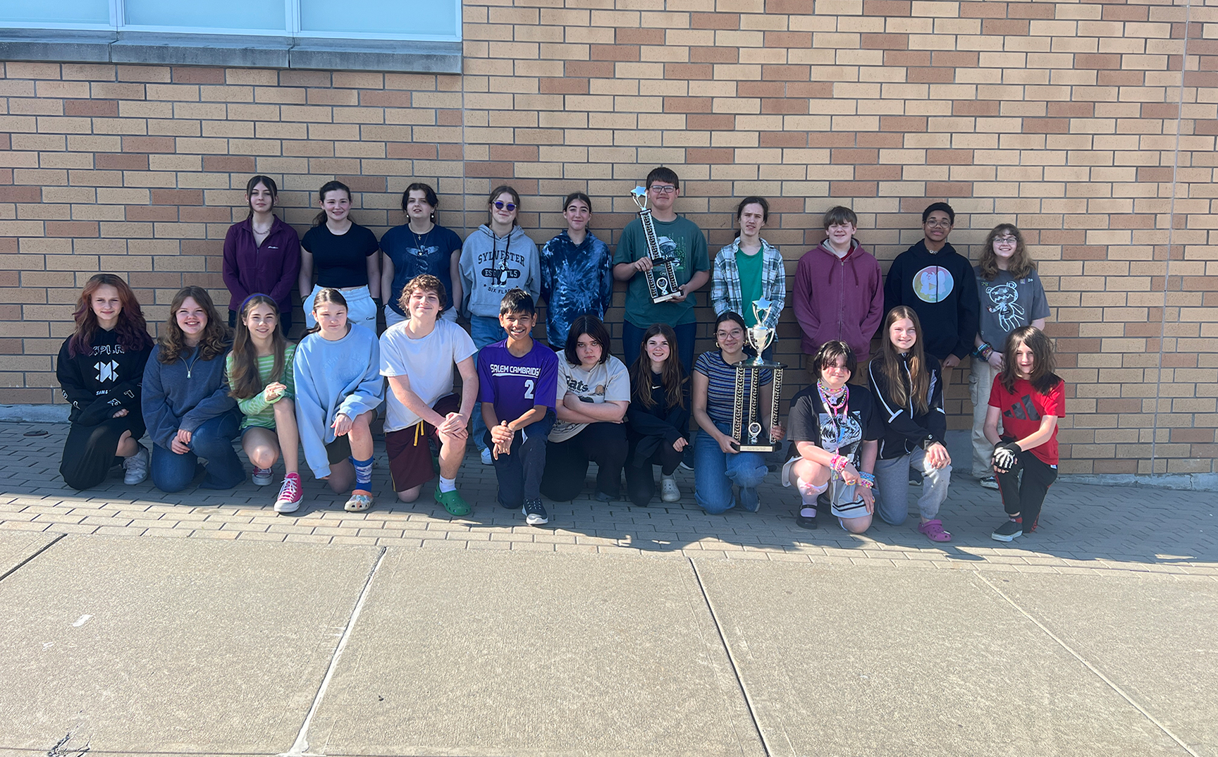 CCS band members posing outside the school with their trophies