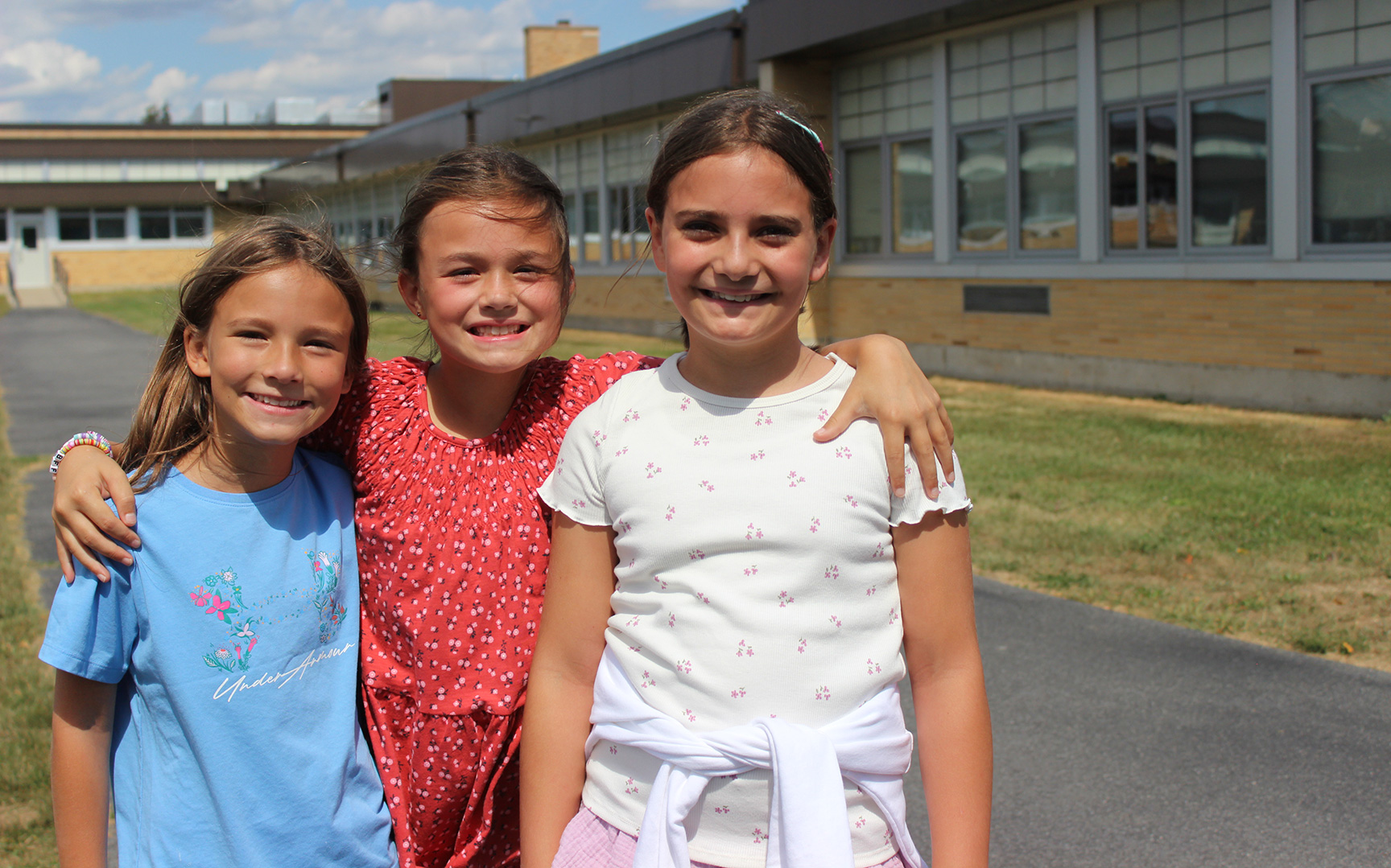 Three elementary girls posing outside at recess
